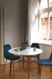 a table with chairs and a laptop on it at King's Little Hideout in Budapest +12 photos