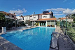a swimming pool in front of a house at Hostel Jardins de São Luís in Setúbal