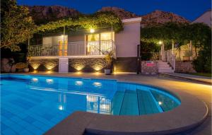 a swimming pool in front of a house at night at Villa Libertas in Mlini