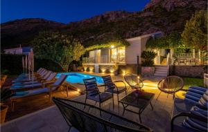 a patio with chairs and a swimming pool at night at Villa Libertas in Mlini