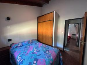 a bedroom with a bed and a wooden cabinet at Chalet para 9 personas in Monte Hermoso +19 photos