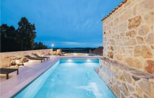 einen Pool mit Bänken neben einer Steinmauer in der Unterkunft Villa Mediterranean Estate in Uskoplje