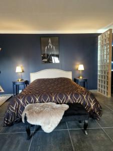 a bedroom with a large bed and two lamps at Love Room La Volupté Spa Privatif in Bétheniville