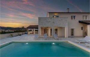 a villa with a swimming pool in front of a house at Villa Stina Murter in Jezera