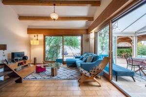 ein Wohnzimmer mit einem blauen Sofa und einem Tisch in der Unterkunft Maison Calme et Sérénité - Welkeys in Montpellier
