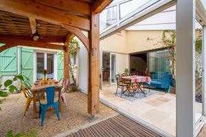 eine Außenterrasse mit einem Tisch und Stühlen in der Unterkunft Maison Calme et Sérénité - Welkeys in Montpellier