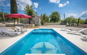 einen Pool mit einem roten Sonnenschirm und Stühlen in der Unterkunft Villa Mirys Hideaway in Dobrinj + 24 Fotos