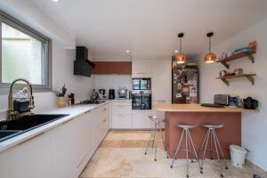 eine Küche mit Spüle und Theke mit Hockern in der Unterkunft Maison Calme et Sérénité - Welkeys in Montpellier + 14 Fotos