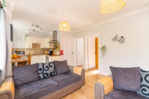 a living room with a couch and a kitchen at The Nook In The Afan Forest Bike Park by StayStaycations in Port Talbot