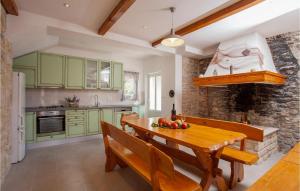 a kitchen with green cabinets and a wooden table at Villa Oliver in Potirna