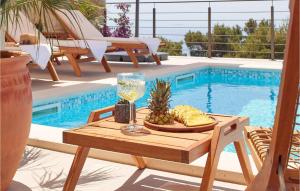 a table with a glass of wine next to a swimming pool at Villa Bianca Hvar in Sveta Nedelja +18 photos