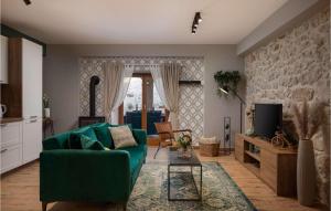 a living room with a green couch and a tv at Villa Kameni Dvori in Sveti Filip i Jakov