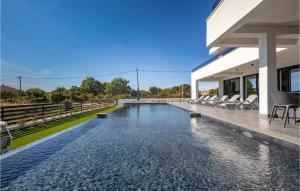 苏科尚Villa One Zadar的房子里有一个无边泳池，周围摆放着椅子。