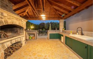 an outdoor kitchen with a stone fireplace and a sink at Villa Palma Zaton in Zaton