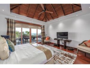 une chambre avec un lit et une télévision à écran plat dans l'établissement Luxury 7 Bedroom Villa In Layan, à Layan Beach