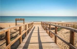 a wooden boardwalk leading to the beach at Gorgeous Home In Santa Pola With Wifi in Santa Pola +23 photos
