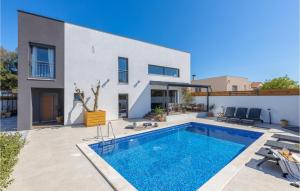 a villa with a swimming pool in front of a house at Villa Arcus in Pakoštane