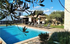 une piscine avec des chaises et une maison dans l'établissement Villa Ginocchetti, à Kaštelir