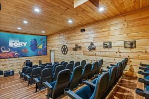 a room with wooden walls and chairs and a screen at Gatlinburg Mansion Cabin in Pittman Center