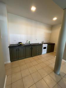 Una cocina vacía con armarios verdes y suelo de baldosas en JUMALETO - Martina, en San Pedro