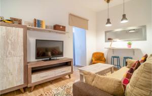 a living room with a couch and a tv at Cozy Apartment In Arcos De La Frontera in Arcos de la Frontera