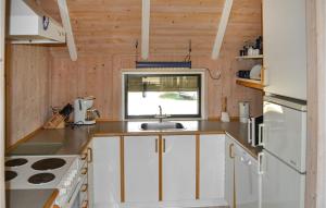 a kitchen with white cabinets and a sink at Holiday Home Slettevej Ii in Skagen