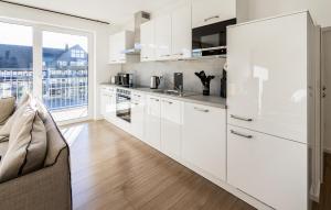 a kitchen with white cabinets and a large window at Gebirgsresort Winterberg in Winterberg