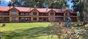 a large brick building with a playground in the yard at DullVino Apartment 8 at Millers Cove in Dullstroom