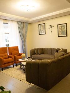 カンパラにあるA home away from homeのソファと椅子2脚のあるリビングルーム +1枚の写真