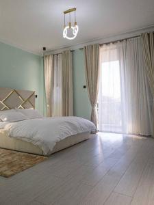 カンパラにあるA home away from homeのベッドと大きな窓のある寝室