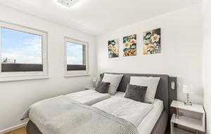 a white bedroom with a bed and two windows at 5 Residenz Panoramablick in Winterberg