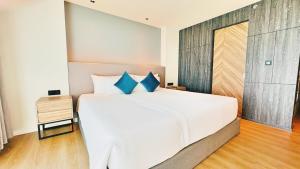 Un dormitorio con una gran cama blanca con almohadas azules. en Luxury studio in a 5-star hotel, near Nai Harn beach, en Rawai Beach