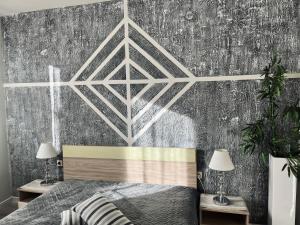 a bedroom with a bed and a gray wall at Бутиков Семеен Хотел БРИО in Velingrad +12 photos