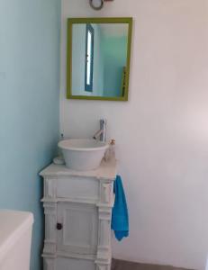 a bathroom with a sink and a mirror on the wall at Cabaña Acacia Mansa 2 in Villa Giardino