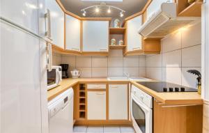 a kitchen with white appliances and wooden cabinets at 2 Bedroom Stunning Home In Fécamp in Fécamp