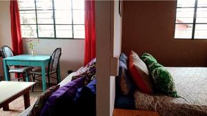 a room with a bed and a table and a window at Cabaña Acacia Mansa 2 in Villa Giardino +2 photos