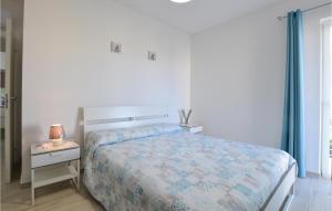 ein Schlafzimmer mit einem Bett und einem Nachttisch mit einer Lampe in der Unterkunft Cozy Home In Marina Di Ragusa With Wifi in Marina di Ragusa