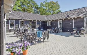 a patio with a table and chairs and a grill at Eight-Bedroom Holiday Home Frederiksværk With A Room Hot Tub 05 in Melby +15 photos