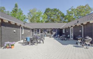 a patio with chairs and tables in front of a building at Eight-Bedroom Holiday Home Frederiksværk With A Room Hot Tub 05 in Melby