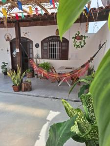 a hammock in the courtyard of a house with plants at Odoyá Casa Hostel in Arraial d'Ajuda
