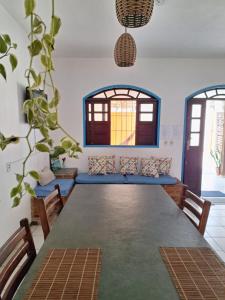 a dining room with a large table and a blue couch at Odoyá Casa Hostel in Arraial d'Ajuda