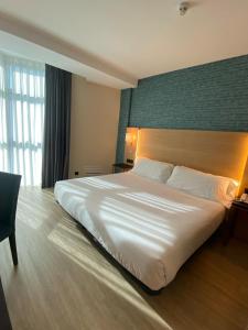 Postel nebo postele na pokoji v ubytování Hotel Zentral Gijón Rey Pelayo