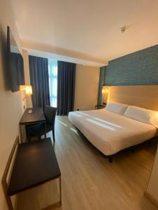 Postel nebo postele na pokoji v ubytování Hotel Zentral Gijón Rey Pelayo