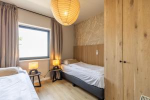 a hotel room with a bed and a window at Huswell - Modern Apartment with Garden, Near Beach in Cadzand