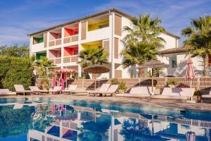 a resort with a swimming pool and palm trees at Hotel Casarose - Cannes Mandelieu in Mandelieu-la-Napoule