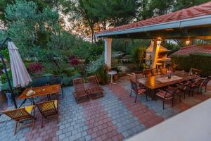 a patio with a table and chairs and an umbrella at House Sanda in Mirce +14 photos