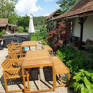 a wooden picnic table and chairs in a garden at Pottos Porta in Váncsod