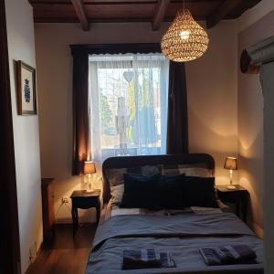 a bedroom with a bed and a window and a chandelier at Pottos Porta in Váncsod +51 photos