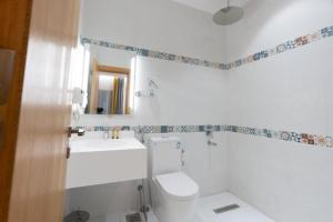 a white bathroom with a toilet and a sink at شاليه نور بشاطئ البرادايس بدرة العروس - للعائلات فقط in Durat  Alarous