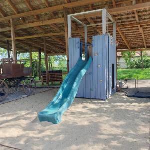 a blue slide in a building with a playground at Pottos Porta in Váncsod